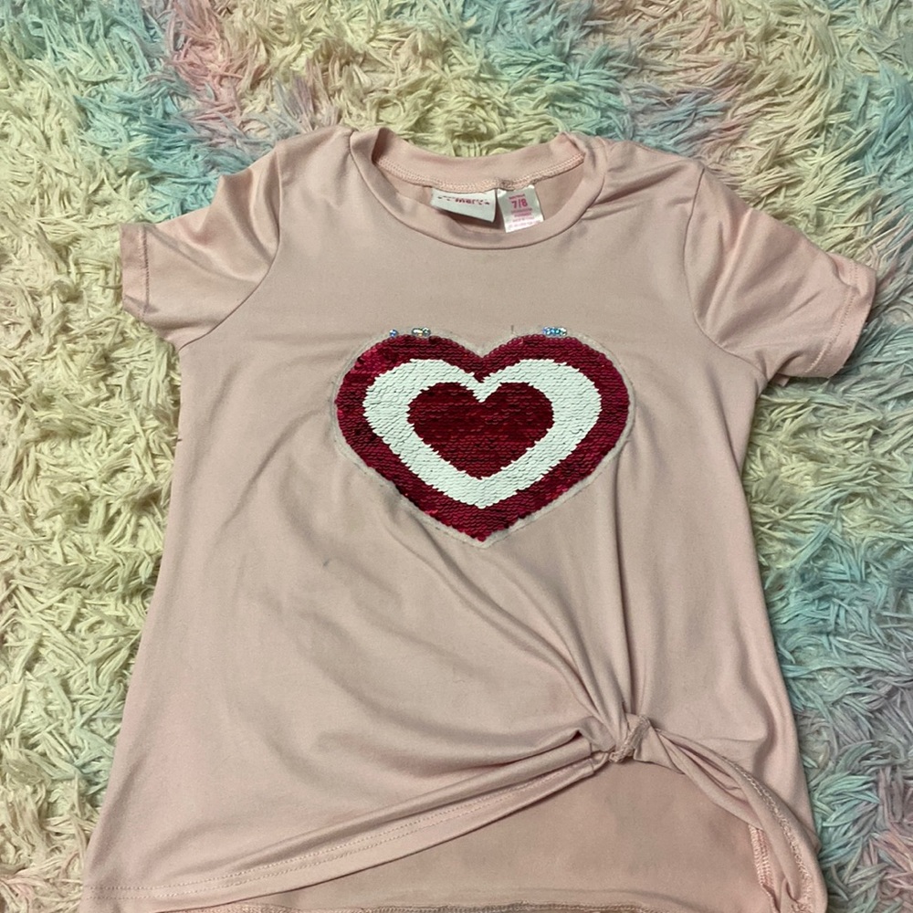 I am selling a kids, short sleeve shirt with a sequins heart on it.